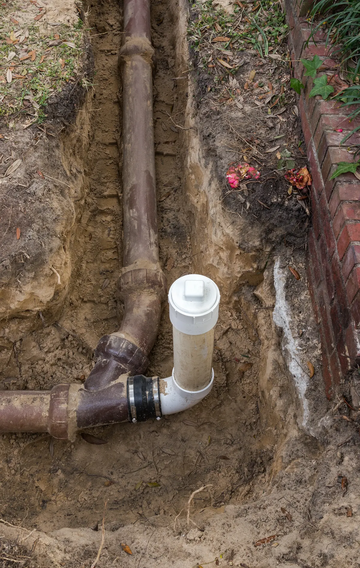 PVC cleanout tied into an old clay sewer line in an open trench